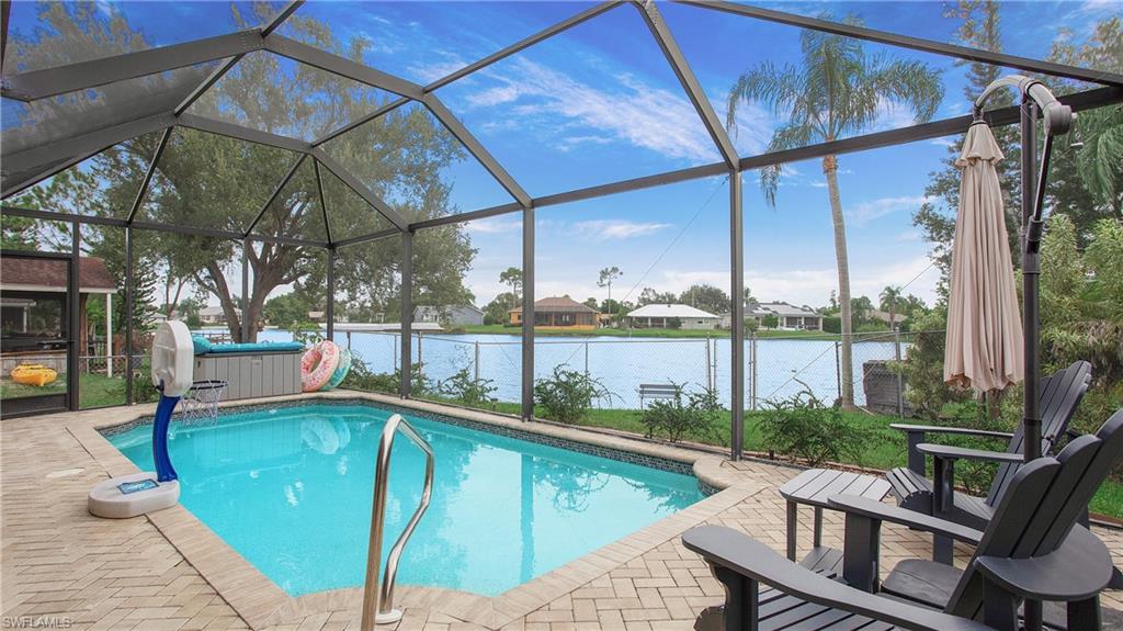 17269 Lee Road Fort Myers, FL 33967 - Photo 19 of 26 View of pool featuring a patio, a water view, a hot tub, and glass enclosure