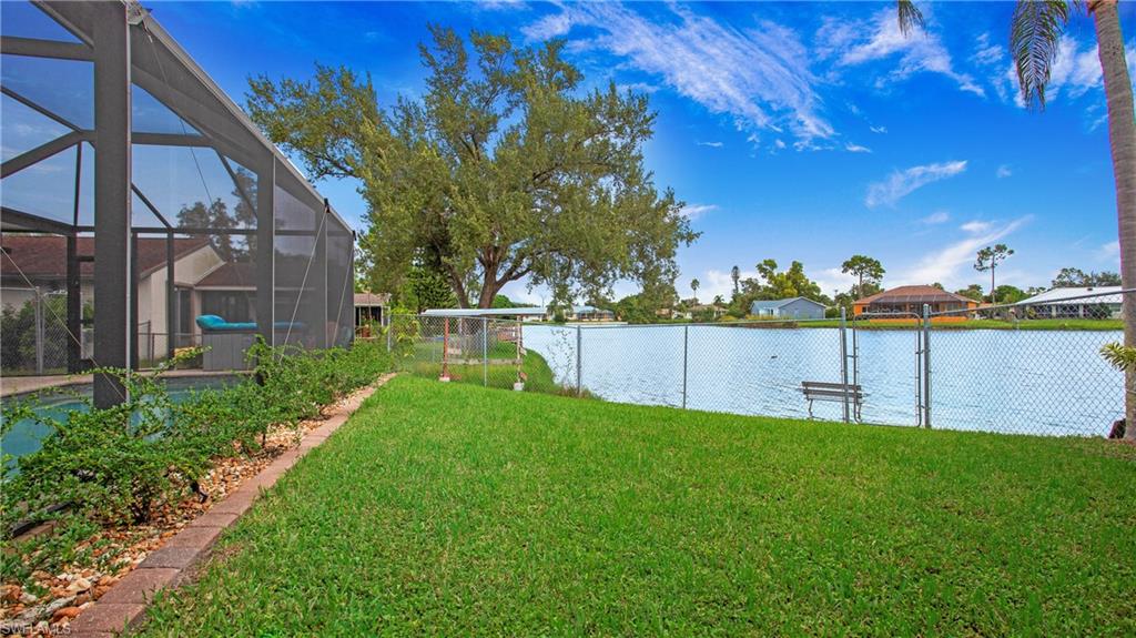 17269 Lee Road Fort Myers, FL 33967 - Photo 22 of 26 View of yard with glass enclosure and a water view