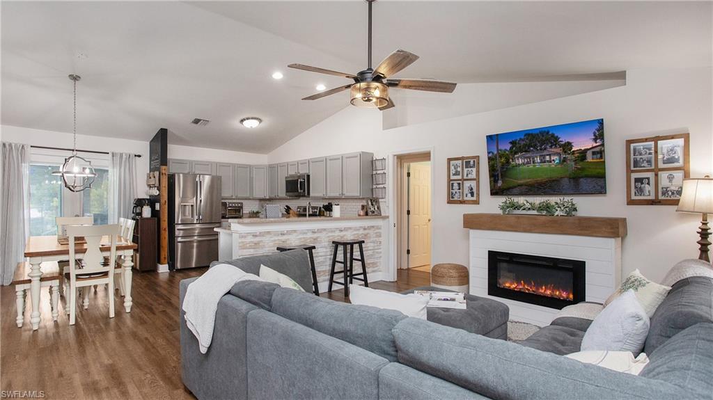 17269 Lee Road Fort Myers, FL 33967 - Photo 5 of 26 Living room featuring ceiling fan with notable chandelier, lofted ceiling, and dark hardwood / wood-style floors