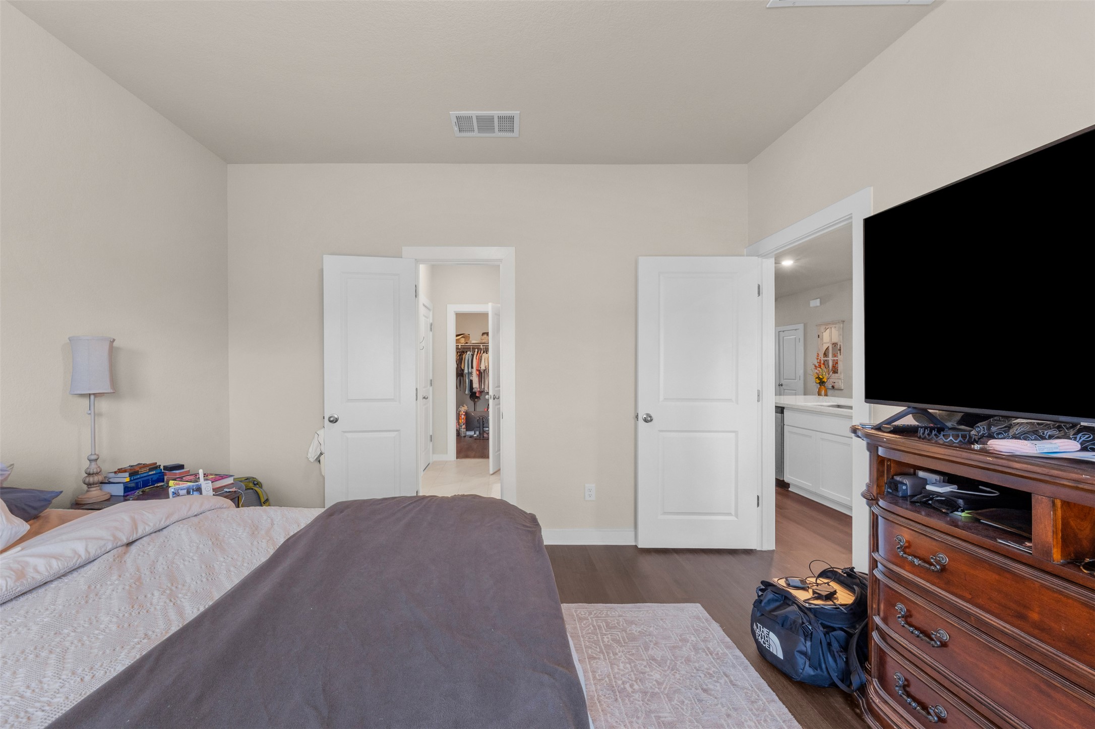 236 Lazy Lizzy Road Jarrell, TX 76537 - Photo 14 of 27 A well-lit bedroom features rich wood flooring, leading to a closet and an adjacent living space.