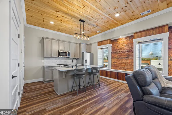 a view of a kitchen with stainless steel appliances granite countertop a stove and a refrigerator
