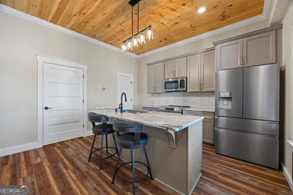 a kitchen with kitchen island a sink appliances and cabinets