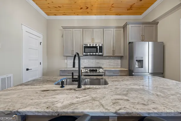 a kitchen with stainless steel appliances granite countertop a stove and a refrigerator