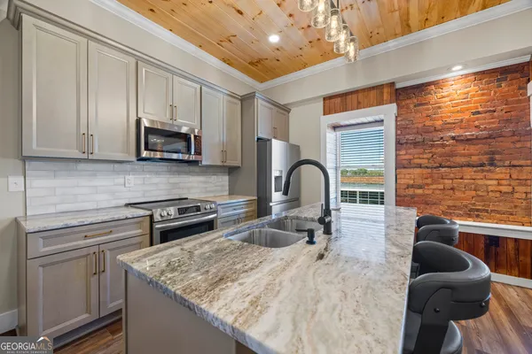 a kitchen with stainless steel appliances granite countertop a sink stove and cabinets