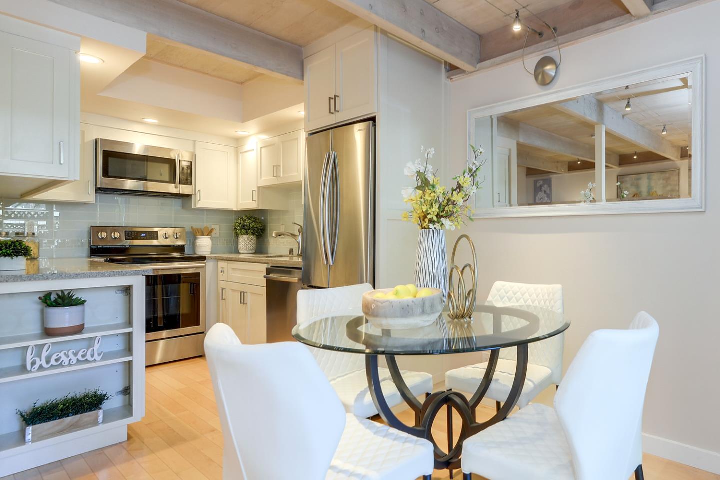 278 Monroe Drive, Unit 14 Mountain View, CA 94040 - Photo 6 of 20 a kitchen with stainless steel appliances granite countertop a dining table chairs refrigerator and microwave