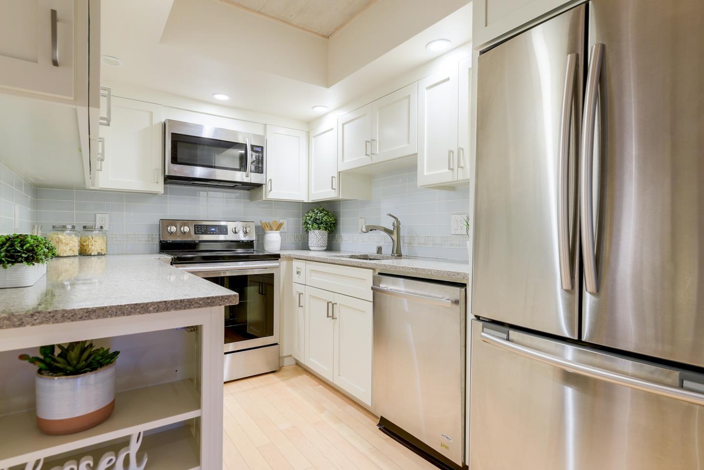 278 Monroe Drive, Unit 14 Mountain View, CA 94040 - Photo 7 of 20 a kitchen with stainless steel appliances a refrigerator sink and white cabinets