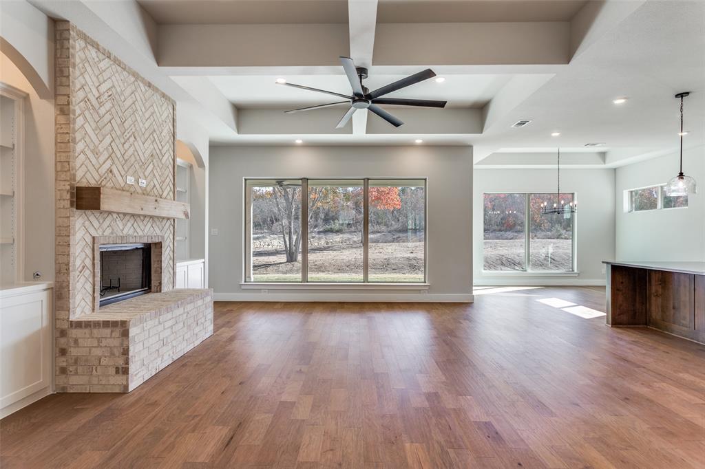 182 Fan Mill Trail Weatherford, TX 76085 - Photo 7 of 31 a view of an empty room with wooden floor fireplace and a window