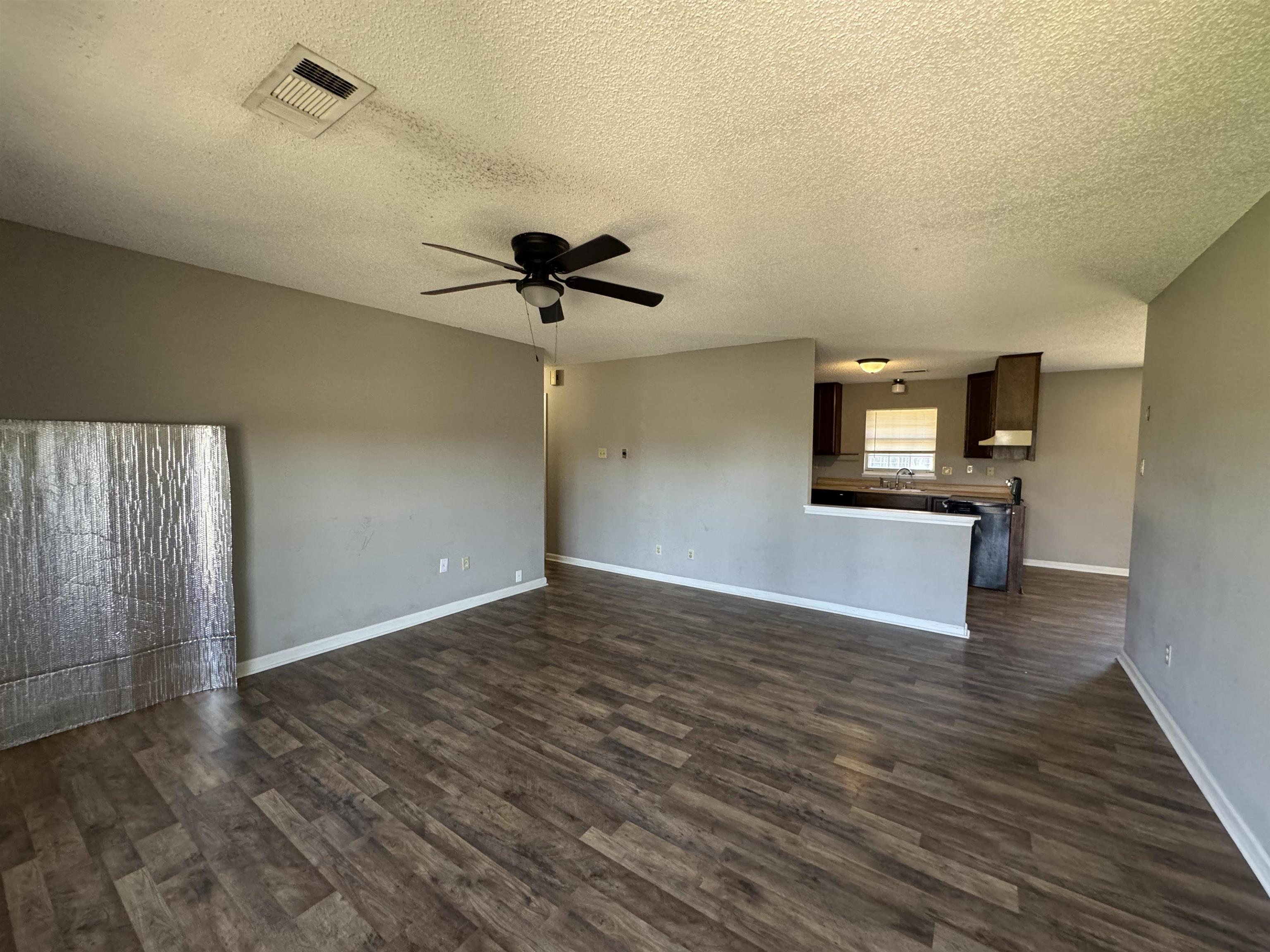 7824 Quito Road Millington, TN 38053 - Photo 5 of 24 Unfurnished living room with dark hardwood / wood-style floors, ceiling fan, and a textured ceiling