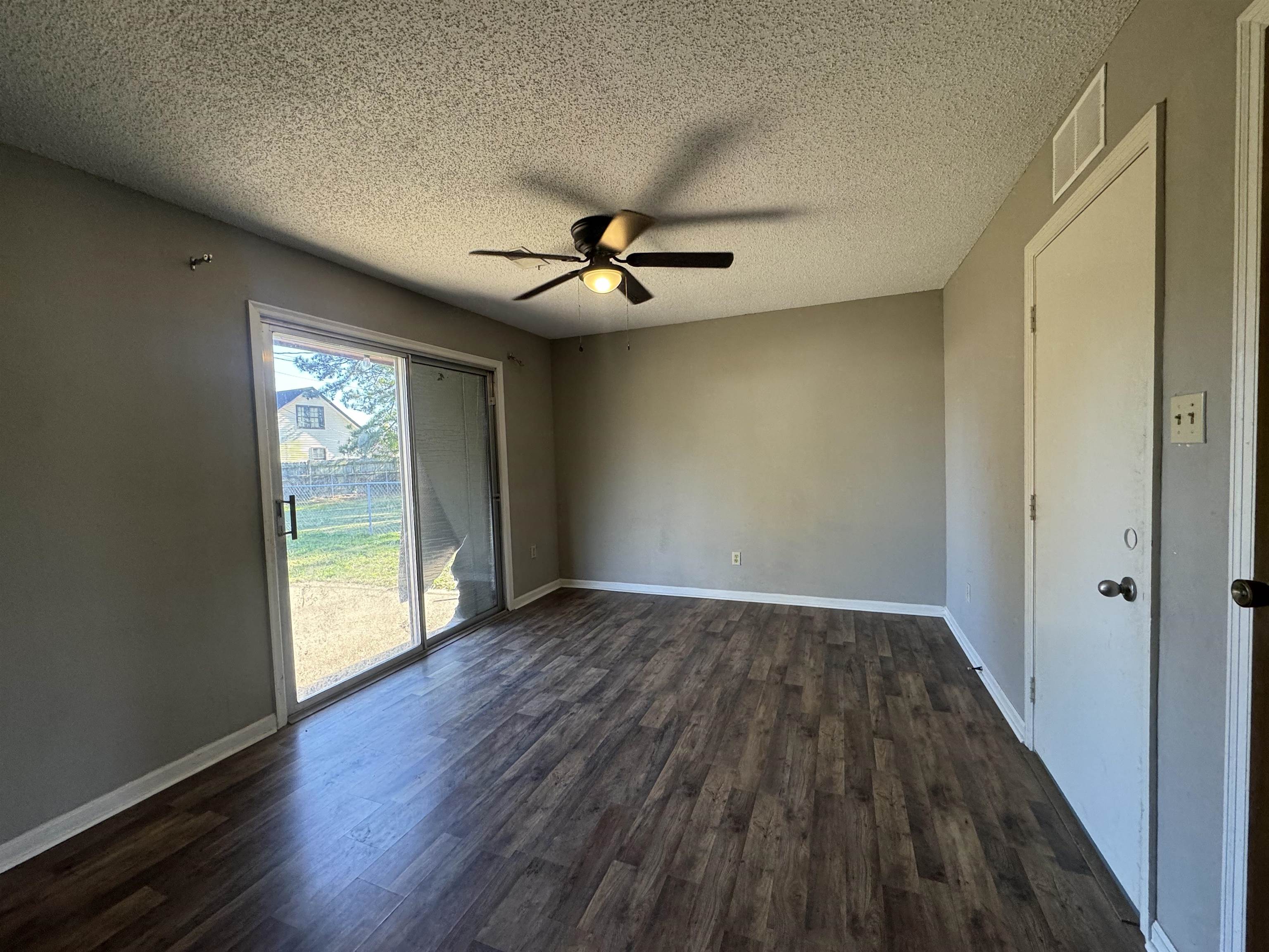 7824 Quito Road Millington, TN 38053 - Photo 10 of 24 Unfurnished room featuring a textured ceiling, ceiling fan, and dark hardwood / wood-style floors