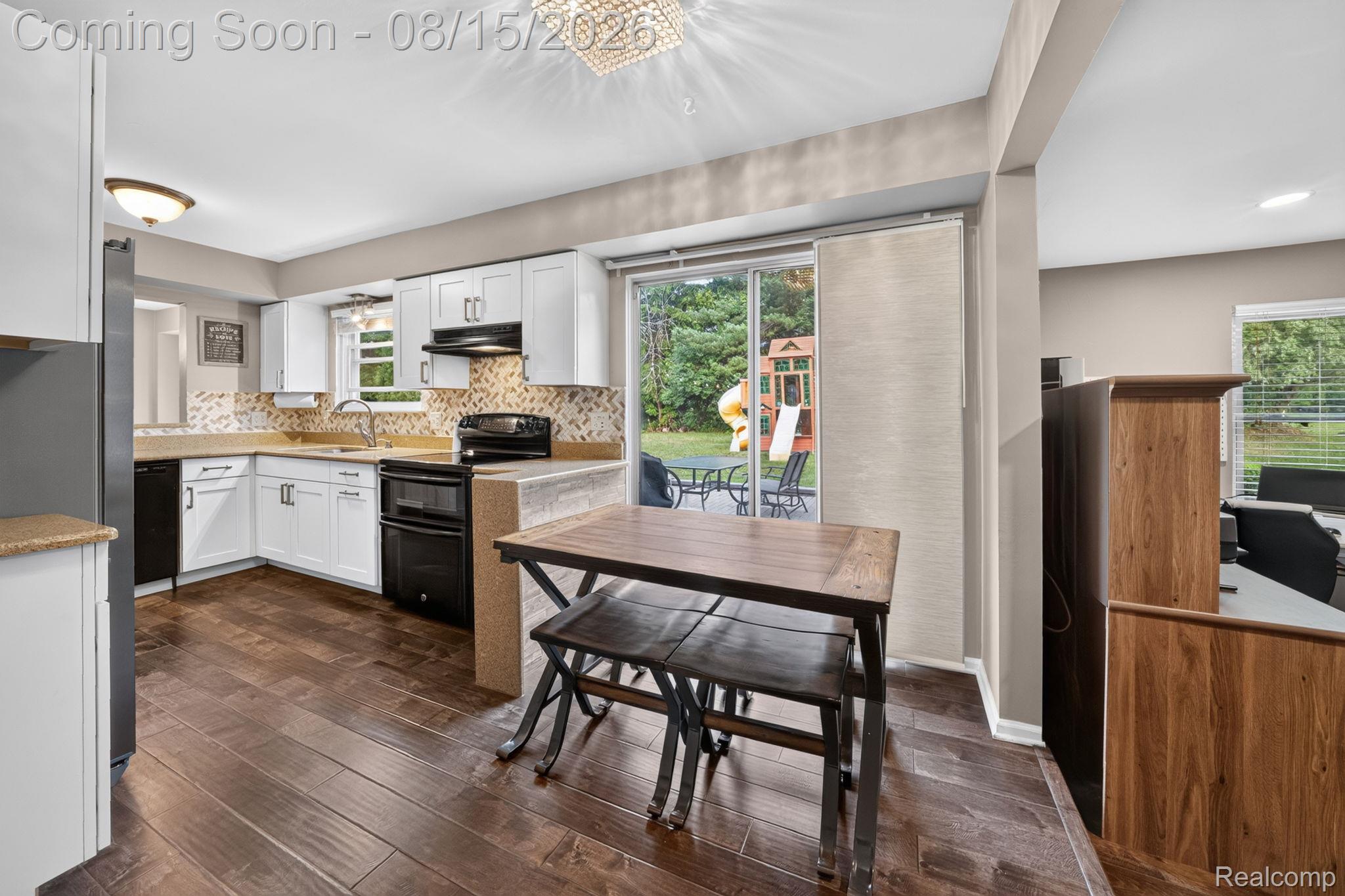 385 Arlington Drive Rochester, MI 48307 - Photo 29 of 47 Kitchen featuring white cabinetry, dark wood-finish flooring, a mosaic tile backsplash, black appliances, and a sliding glass door