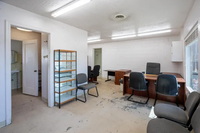a view of a workspace with furniture and a window