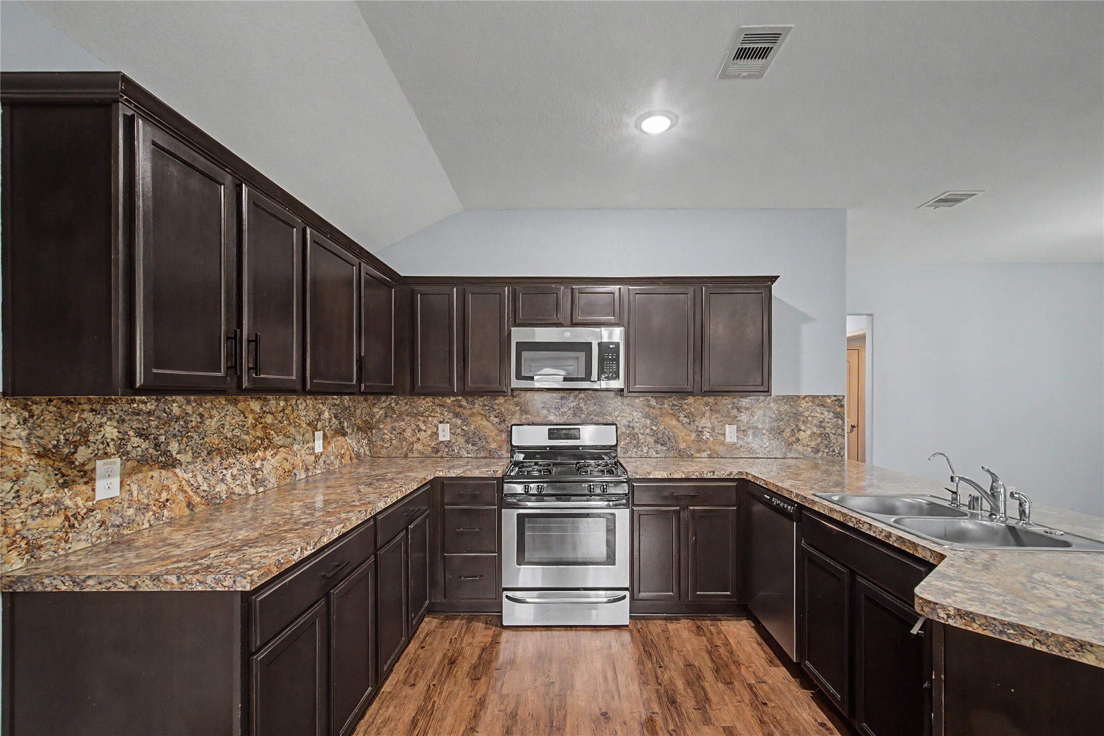 16430 Rodeo River Road Houston, TX 77049 - Photo 24 of 34 a kitchen with a sink stove top oven and cabinets