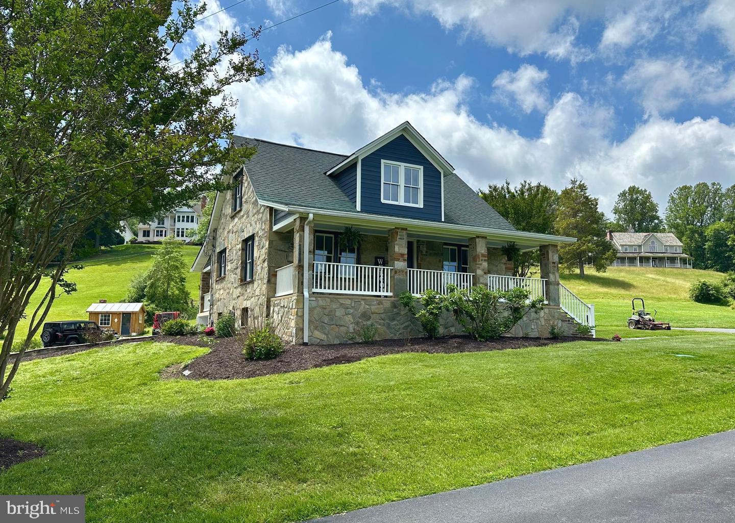 12301 Chapel Road Clifton, VA 20124 - Photo 3 of 3 Charming stone home with lush greenery.
