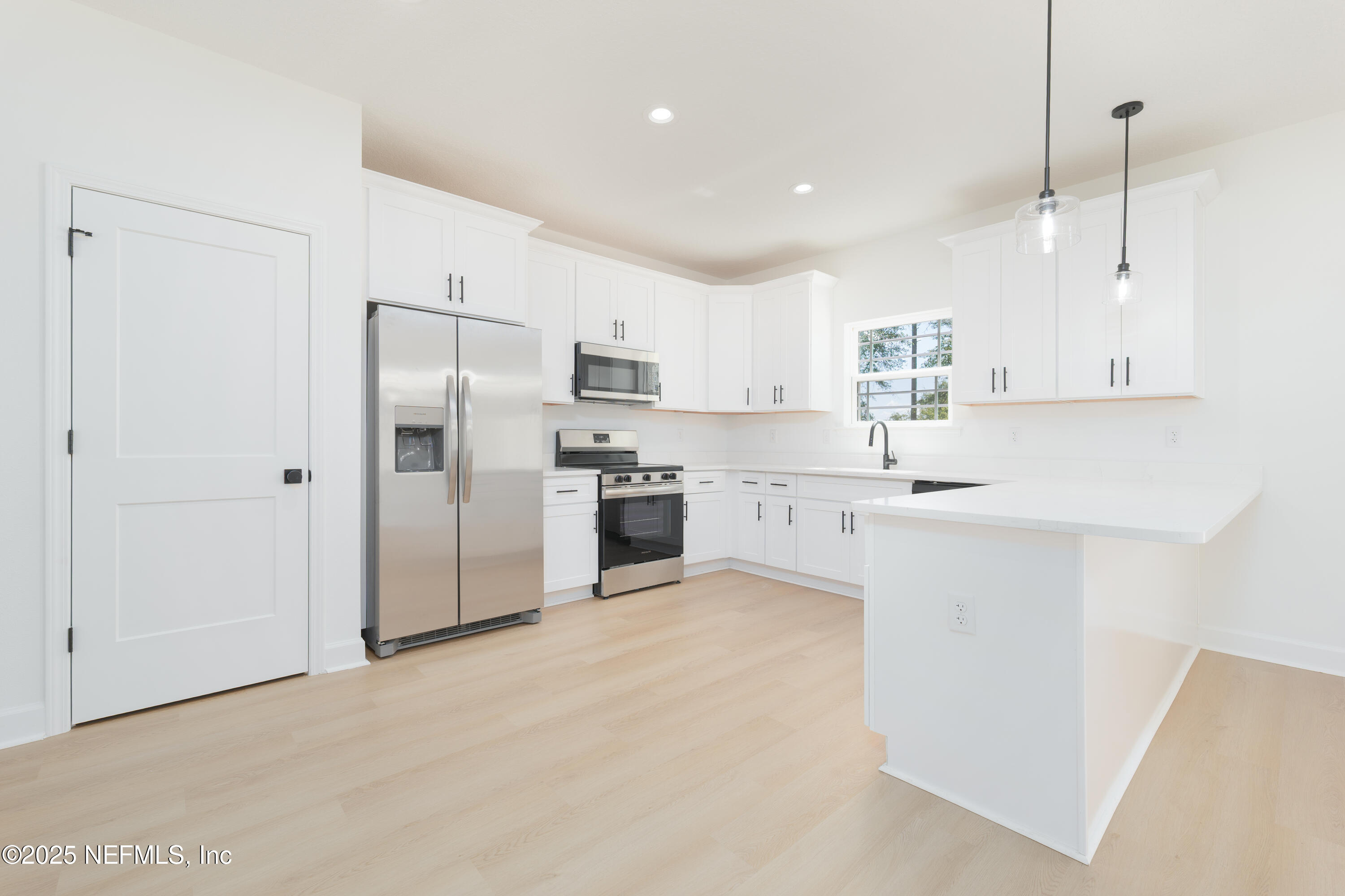 5294 County Road 352 Keystone Heights, FL 32656 - Photo 5 of 23 a kitchen with white cabinets and stainless steel appliances