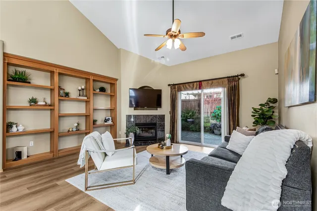 a living room with furniture fireplace and a large window