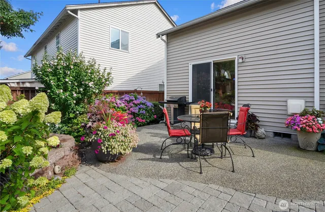 a view of a tables and chairs in back yard of the house