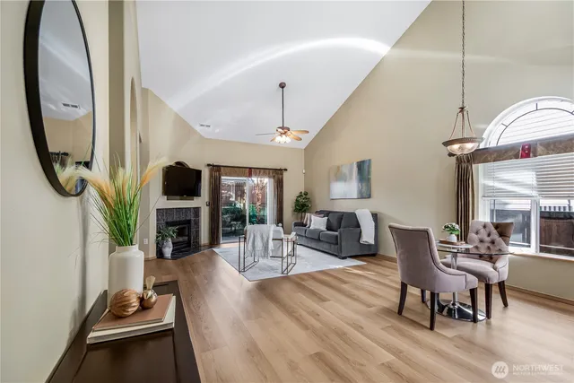 a living room with furniture a fireplace a rug and a window