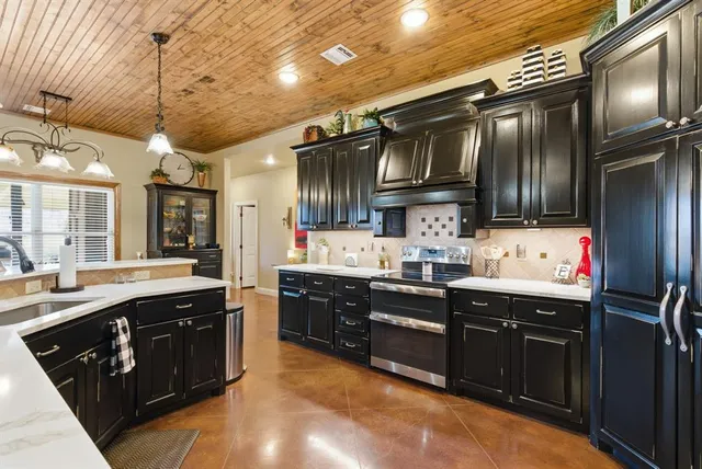 a kitchen with granite countertop a sink stainless steel appliances and cabinets