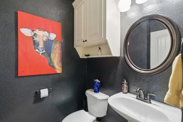 a bathroom with a toilet a sink and a mirror