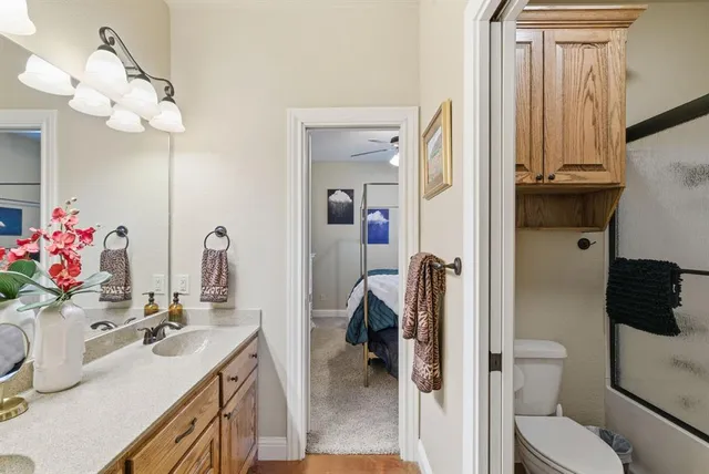 a bathroom with a sink vanity mirror and toilet