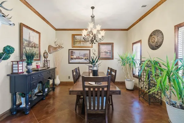 a view of a dining room with furniture a chandelier and wooden floor