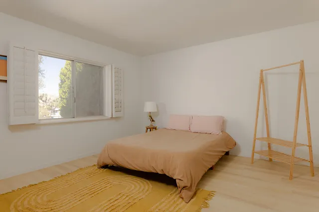 a bedroom with a bed and a window