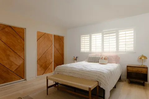 a bedroom with a bed chair and a window