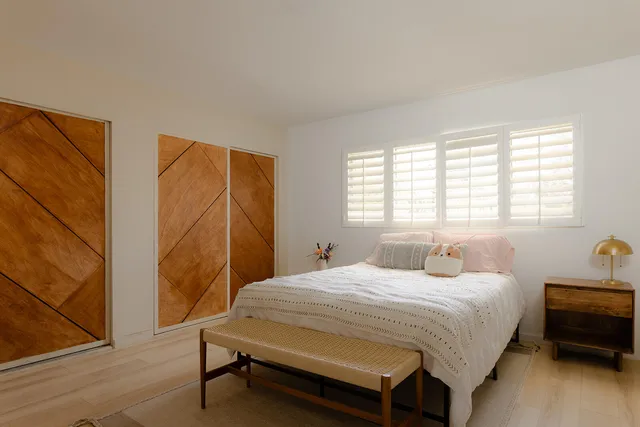 a bedroom with a bed chair and a window