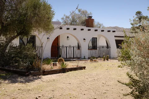a view of a dry yard covered with snow in the background