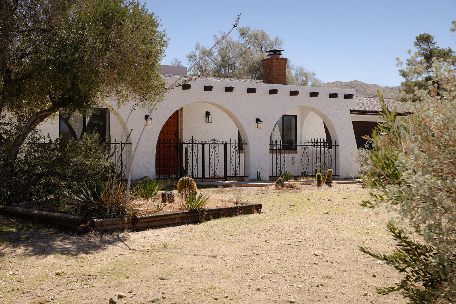 7995 Grand Avenue Yucca Valley, CA 92284 - Photo 2 of 26 a view of a dry yard covered with snow in the background
