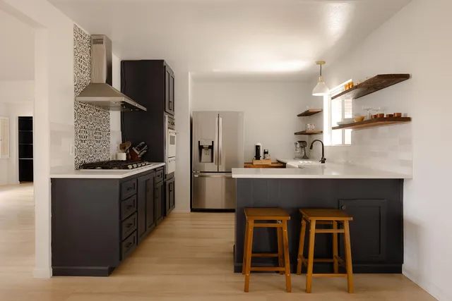 a kitchen with stainless steel appliances kitchen island granite countertop a stove and a refrigerator