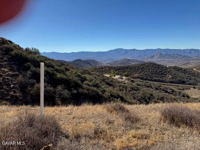 a view of a large mountain with a mountain in the background