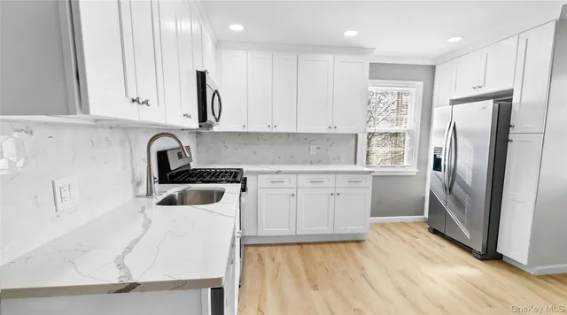 a kitchen with stainless steel appliances granite countertop a stove a sink and a microwave