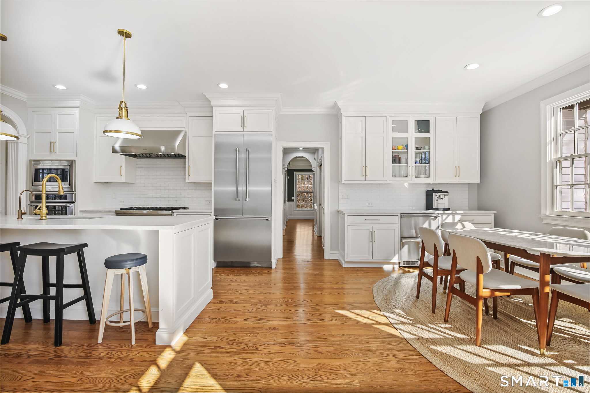 323 Smith Ridge Road New Canaan, CT 06840 - Photo 11 of 39 a kitchen with stainless steel appliances granite countertop a refrigerator a stove a sink dishwasher and a dining table with wooden floor