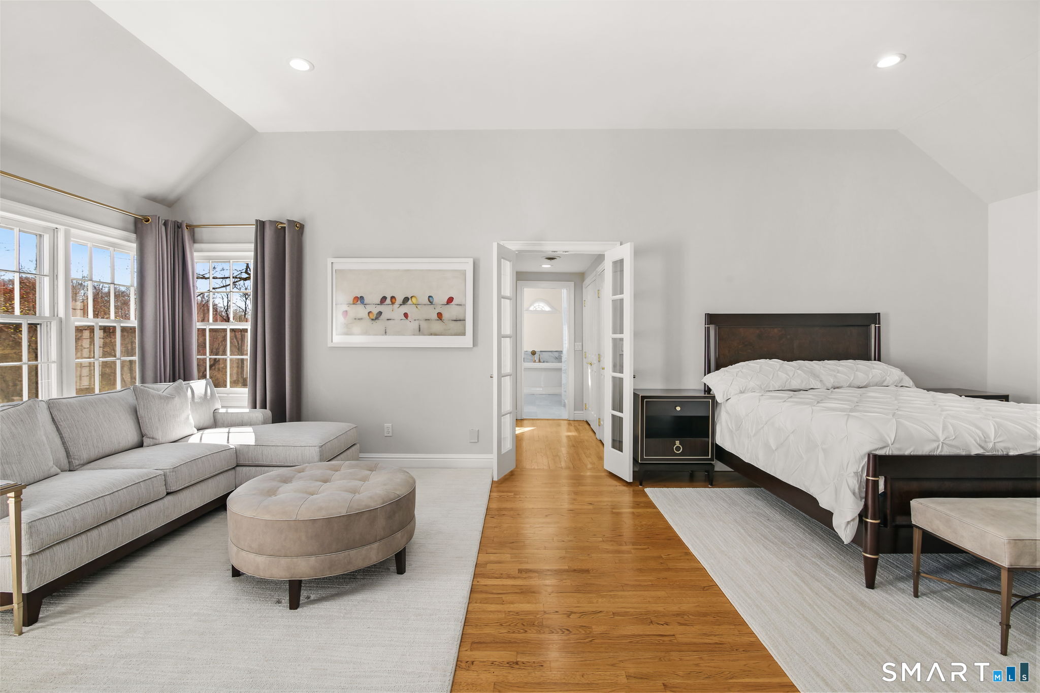 323 Smith Ridge Road New Canaan, CT 06840 - Photo 20 of 39 a spacious bedroom with a bed a couch and a large window