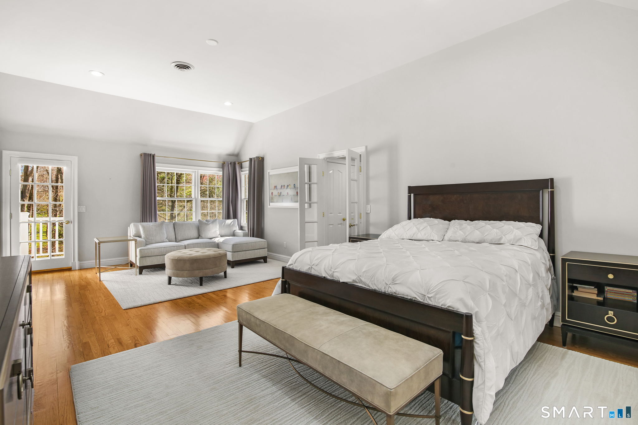 323 Smith Ridge Road New Canaan, CT 06840 - Photo 23 of 39 a spacious bedroom with a bed a couch and a potted plant on the table