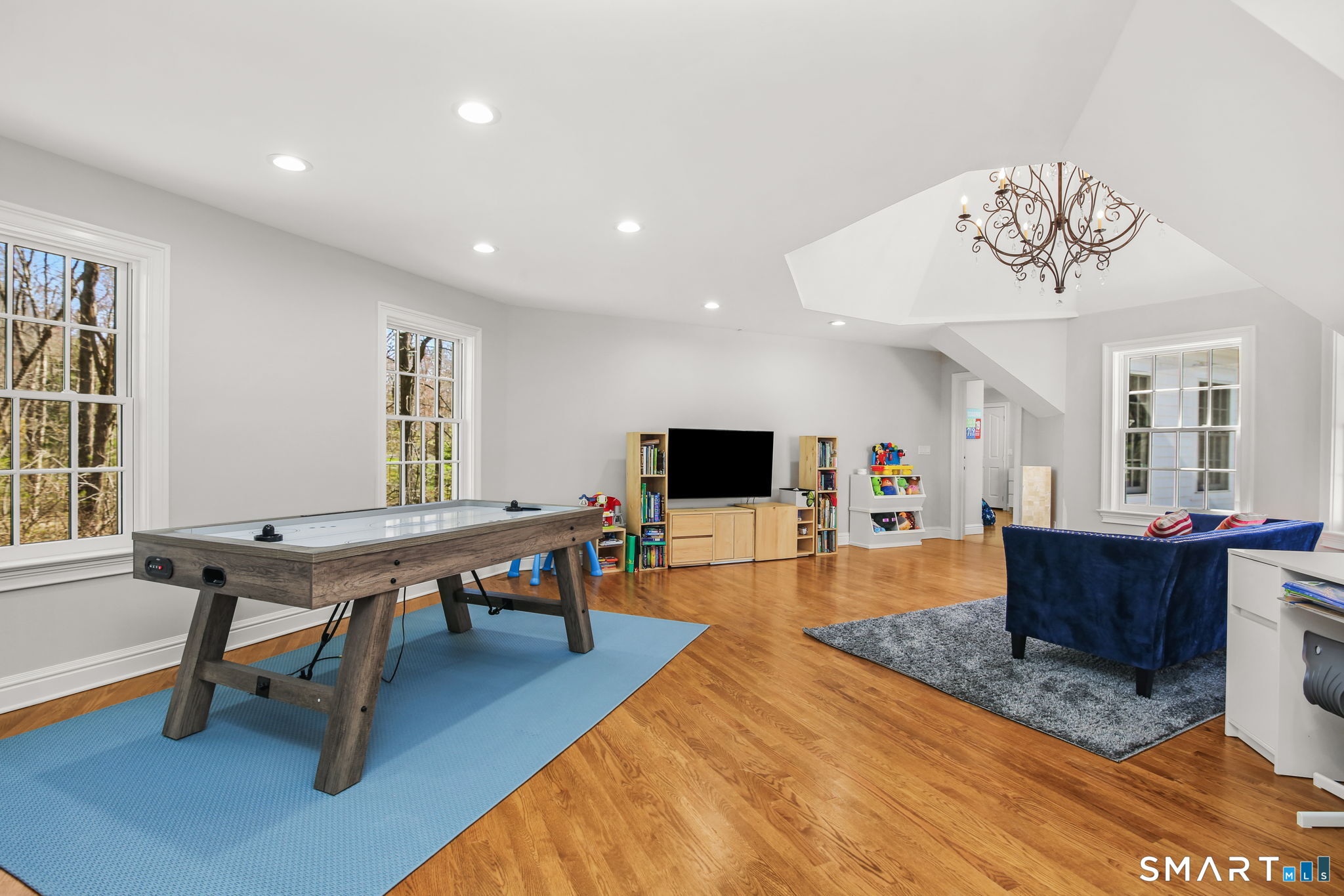 323 Smith Ridge Road New Canaan, CT 06840 - Photo 30 of 39 a living room with furniture a dining table and a flat screen tv