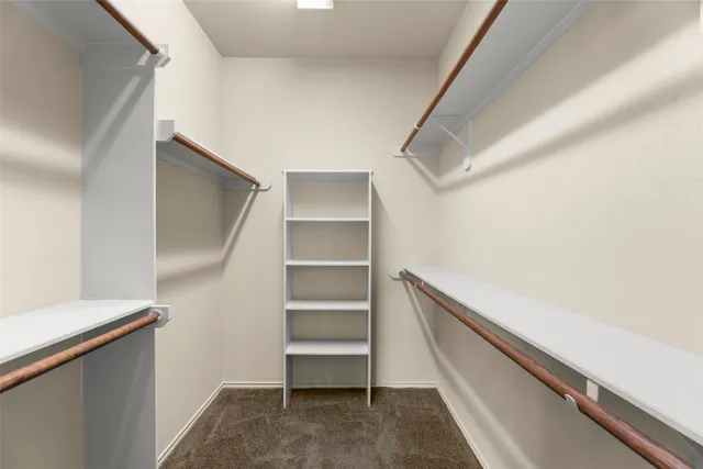 a view of walk in closet with empty racks