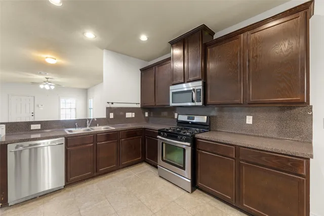 a kitchen with stainless steel appliances granite countertop a sink stove and microwave