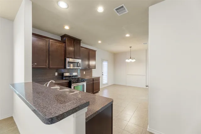 a kitchen with stainless steel appliances granite countertop a sink refrigerator and cabinets