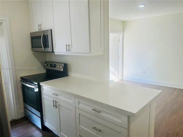 a metallic refrigerator freezer sitting inside of a kitchen