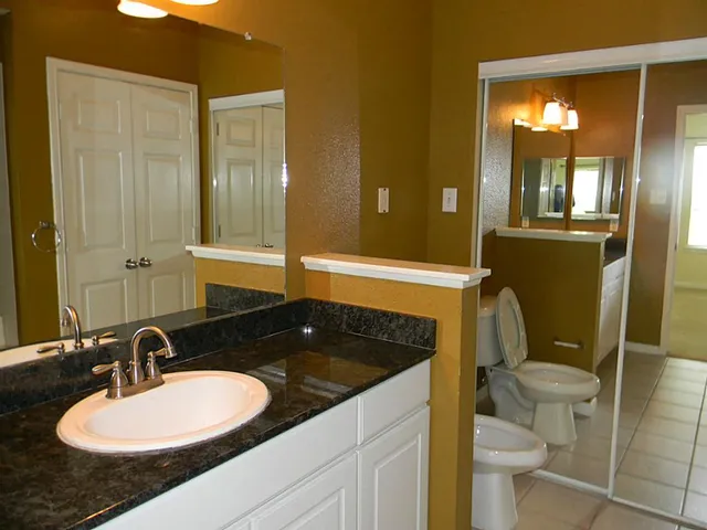 a bathroom with a granite countertop sink and a mirror