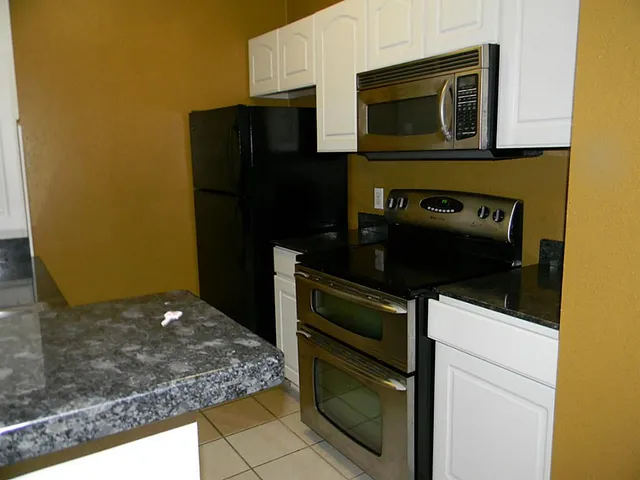 a kitchen with granite countertop cabinets and steel stainless steel appliances