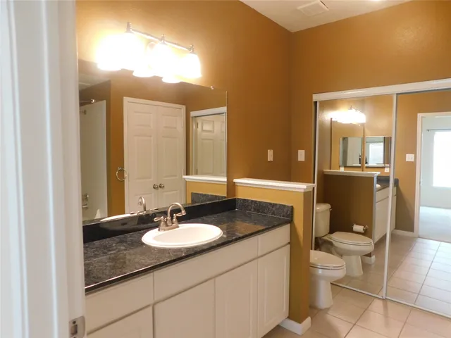 a bathroom with a granite countertop sink toilet a mirror and a shower