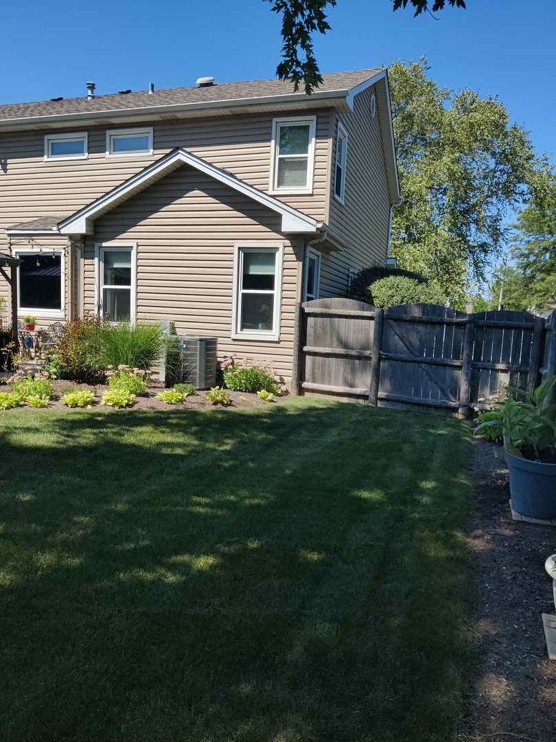 1681 Boulder Ridge Drive Bolingbrook, IL 60490 - Photo 4 of 17 a front view of a house with a garden and plants