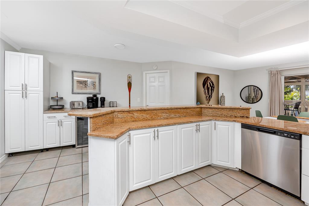 404 Maxwell Place Indian Rocks Beach, FL 33785 - Photo 11 of 66 a kitchen with granite countertop a sink and white cabinets