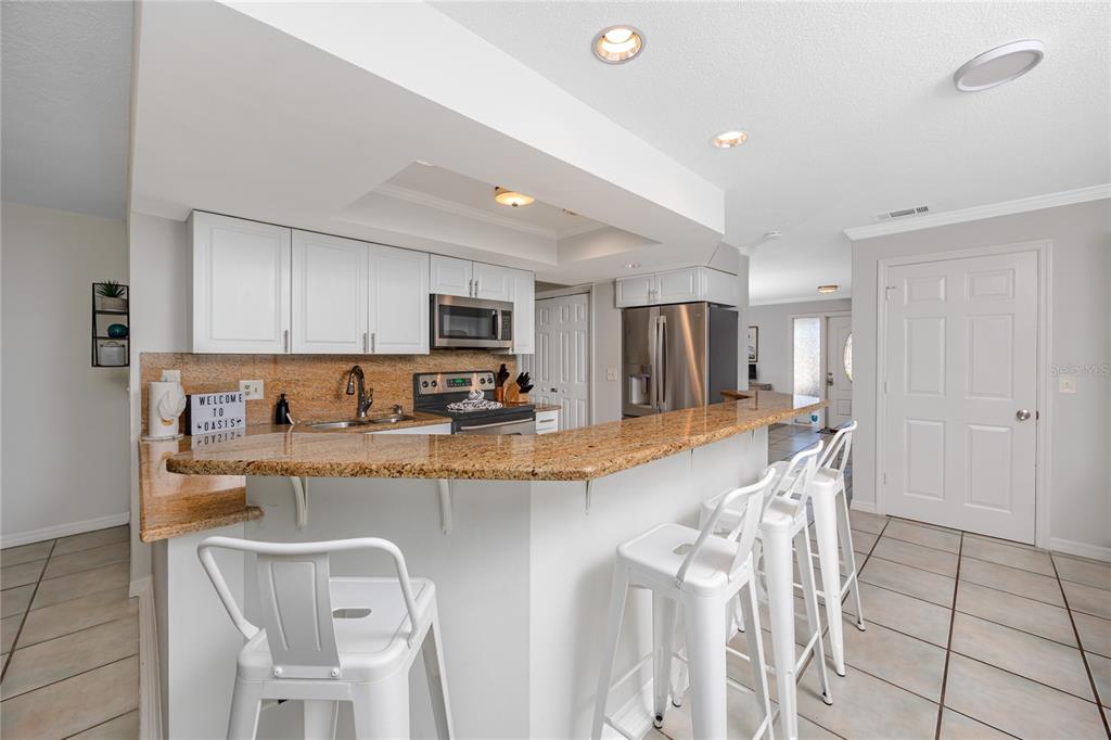 404 Maxwell Place Indian Rocks Beach, FL 33785 - Photo 12 of 66 a large kitchen with granite countertop a large counter top appliances and cabinets