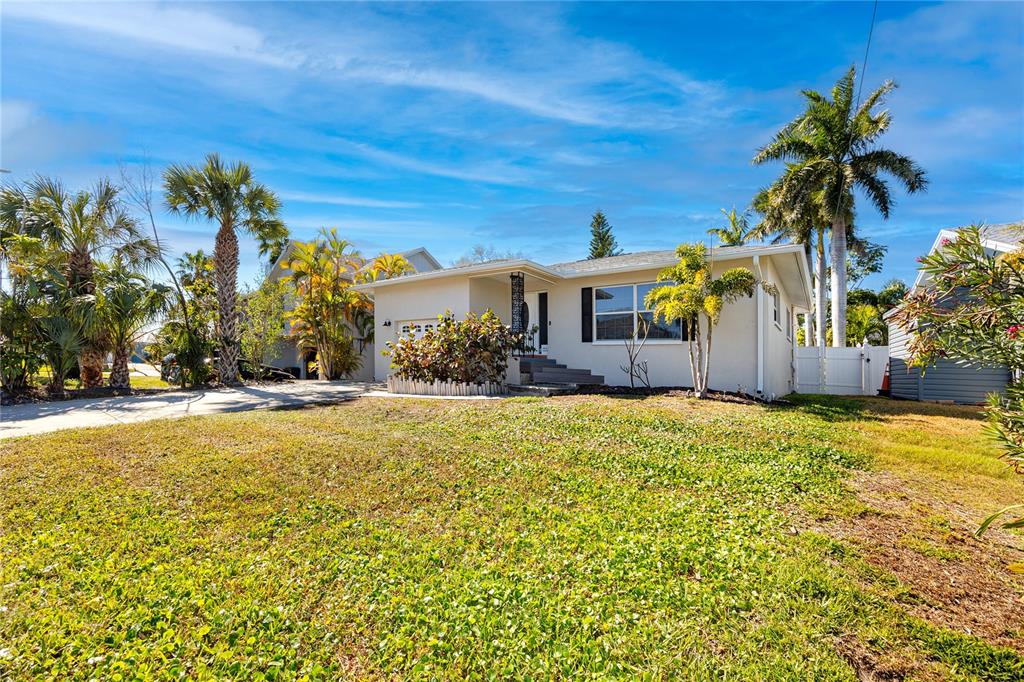 404 Maxwell Place Indian Rocks Beach, FL 33785 - Photo 65 of 66 a view of a house with palm trees and a yard
