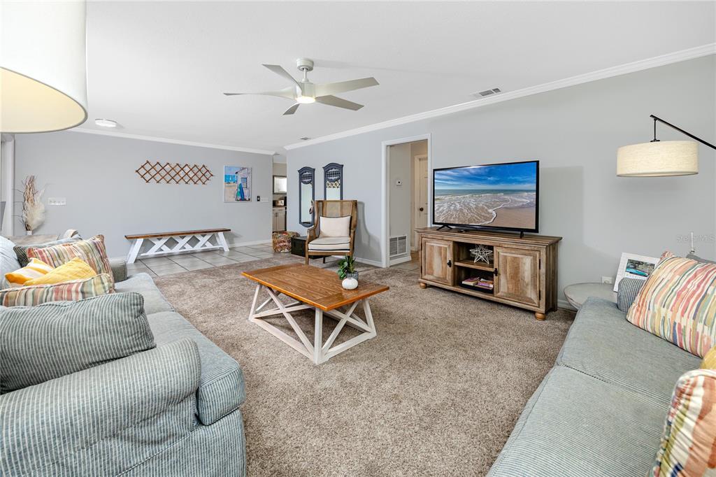 404 Maxwell Place Indian Rocks Beach, FL 33785 - Photo 8 of 66 a living room with furniture a flat screen tv and a lamp