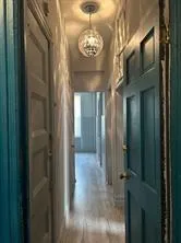a view of a hallway with windows and chandelier